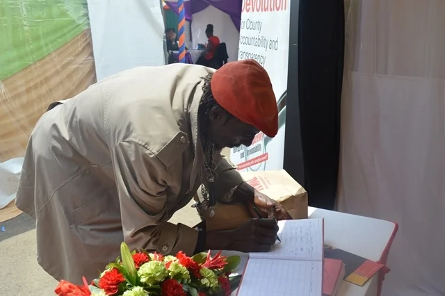 A member of the public signs KHRC visitor's book