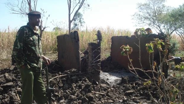 An Administration Police Officer next to a burnt down house in Nyangore sub-location following clashes that took place on February 25, 2012
